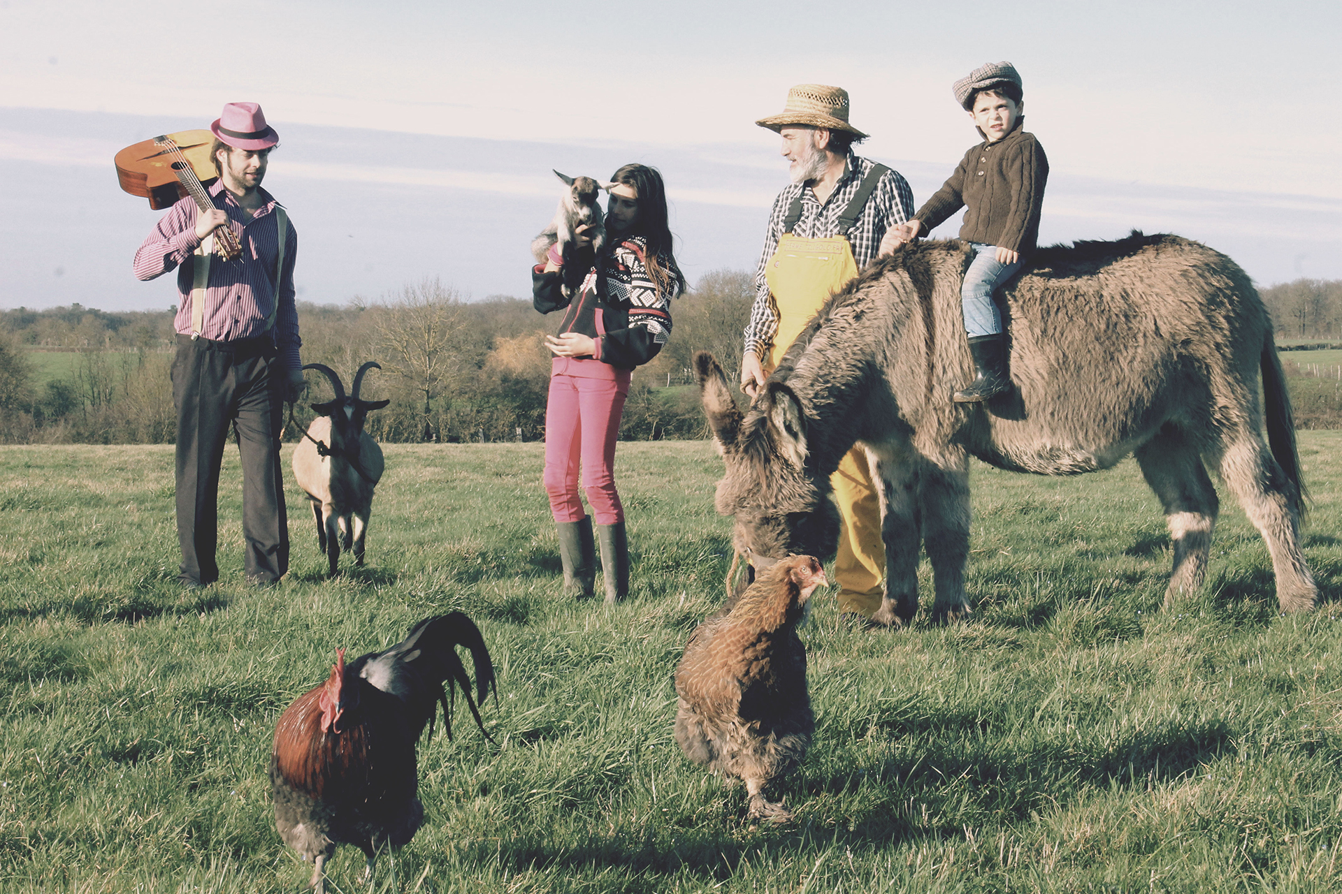 Le fermier Tiligolo, le musicien Fanfare et les enfants se promènent dans un champ avec les animaux de la ferme